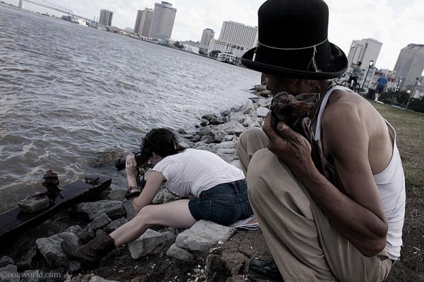 Man with wood watching woman photographer, New Orleans